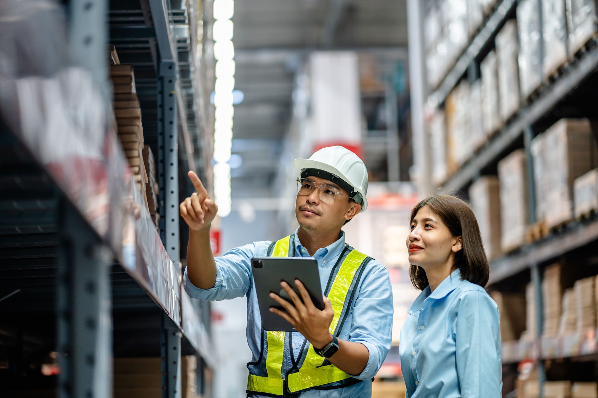 Warehouse staff working together using digital tablets to check the stock inventory on shelves in large warehouses, smart warehouse management system, supply chain, logistic network technology concept